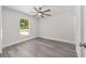 Cozy bedroom featuring gray wood-look flooring, a ceiling fan, and a window with neighborhood views at 15304 Sw 27 Ln, Ocala, FL 34481