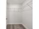Walk-in closet featuring built-in shelving and gray wood-look flooring at 15304 Sw 27 Ln, Ocala, FL 34481