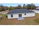 Rear view of a single-story house with gray roof and sliding glass doors at 15304 Sw 27 Ln, Ocala, FL 34481