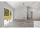 Bright living room boasting gray wood-look flooring, modern lighting, and sliding glass doors to the backyard at 15304 Sw 27 Ln, Ocala, FL 34481