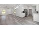 Open-concept living room featuring gray wood-look flooring, a modern light fixture, and stainless steel appliances at 15304 Sw 27 Ln, Ocala, FL 34481