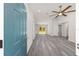 An open-concept living space with grey hardwood floors, a ceiling fan, and natural light shining through sliding glass doors at 15304 Sw 27 Ln, Ocala, FL 34481