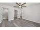 Bright main bedroom featuring gray wood-look flooring, a ceiling fan, and an en-suite bathroom with marble tile at 15304 Sw 27 Ln, Ocala, FL 34481