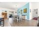 Dining area with white table and chairs, light wood floors, and blue accent wall at 1561 Ne 160Th Pl, Citra, FL 32113