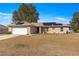 Inviting single-story home with solar panels, a two-car garage, and a well-maintained lawn at 1561 Ne 160Th Pl, Citra, FL 32113