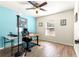 Bright office space with wood-look flooring, a desk setup, and a serene blue accent wall at 1561 Ne 160Th Pl, Citra, FL 32113