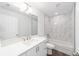 Bright bathroom featuring a shower-tub combo with white marble-style tile, and white vanity with granite countertop at 2270 Sw 141St Ter, Ocala, FL 34481