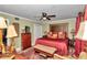 King-size bed, wood furniture, and red accents in this large bedroom at 2418 Ne 7Th St # 10, Ocala, FL 34470