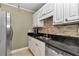 Updated kitchen featuring white cabinets and stone backsplash at 2418 Ne 7Th St # 10, Ocala, FL 34470