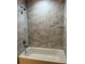 Clean bathroom with marble-look tile and a shower/tub combo at 2515 Nw 63Rd Pl, Ocala, FL 34475