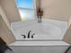 Corner bathtub with marble-look tile and a large window for natural light at 2701 Sw 175Th Loop, Ocala, FL 34473