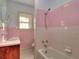 Clean bathroom with pink and white tile, bathtub and shower at 309 Ne Sanchez Ave, Ocala, FL 34470