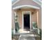 Inviting front porch with two green chairs and a welcome mat at 3396 Parkchester Square Blvd # 103, Orlando, FL 32835