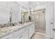 Bright bathroom featuring double sink vanity with granite counters and shower with glass doors at 5450 Nw 46Th Lane Rd, Ocala, FL 34482