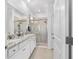 Bright bathroom featuring double sink vanity with granite counters and shower with glass doors at 5450 Nw 46Th Lane Rd, Ocala, FL 34482