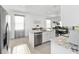 Kitchen island features a stainless steel dishwasher and sink with white cabinetry at 5450 Nw 46Th Lane Rd, Ocala, FL 34482