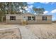 Tan mobile home with gray trim, wood steps, and a landscaped yard at 6555 Se 165Th Ave, Ocklawaha, FL 32179