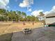 Firepit and patio in spacious backyard with wooden fence and trees at 7045 Greengrove Blvd, Clermont, FL 34714