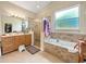 Double vanity bathroom with a walk-in shower and garden tub at 7045 Greengrove Blvd, Clermont, FL 34714