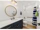 Bathroom with a navy vanity, white tile, and a tub at 7865 Sw 89Th Cir, Ocala, FL 34481