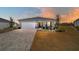 One-story home with light gray siding, paver driveway, and landscaped yard at dusk at 7865 Sw 89Th Cir, Ocala, FL 34481