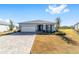 One-story home with light gray siding, paver driveway, and landscaped yard at 7865 Sw 89Th Cir, Ocala, FL 34481