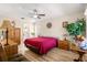 Bright bedroom with wood-look floors, a red bedspread, and ample closet space at 8594 Sw 61St Ct, Ocala, FL 34476