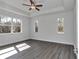 Bright bedroom with wood-look floors, ceiling fan, and large windows at 8786 Sw 127 Ave, Dunnellon, FL 34432