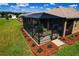 Aerial view of a cozy screened patio bordered by manicured landscaping and a lush green lawn at 8902 Sw 75Th Loop, Ocala, FL 34481