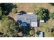 An aerial view displays the home with mature foliage, outbuildings, and fenced yard at 9352 Ne 27Th Ter, Anthony, FL 32617