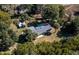 Aerial view shows a home with outbuildings and fenced yard surrounded by mature trees at 9352 Ne 27Th Ter, Anthony, FL 32617