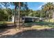 A fenced-in backyard featuring a screened-in porch, and mature palm trees at 9352 Ne 27Th Ter, Anthony, FL 32617