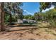 Expansive backyard featuring a covered patio, mature trees, and a fenced perimeter at 9352 Ne 27Th Ter, Anthony, FL 32617