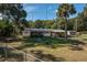 Home with a spacious yard that includes a screened-in porch and mature palm trees at 9352 Ne 27Th Ter, Anthony, FL 32617