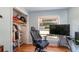 Bedroom featuring hardwood floors, blue walls and a window overlooking the yard at 9352 Ne 27Th Ter, Anthony, FL 32617