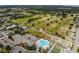 Overhead image of a community clubhouse, pool, lawn bowling, parking, and a golf course nearby at 9651 Se 137Th Street Rd, Summerfield, FL 34491