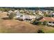 Aerial view of a residential home featuring a screened-in lanai with landscaped backyard in a vibrant community at 9651 Se 137Th Street Rd, Summerfield, FL 34491