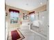 A bathroom featuring a glass-door shower, separate tub, and a window that provides outside views at 9651 Se 137Th Street Rd, Summerfield, FL 34491