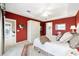 Inviting bedroom with vibrant red walls, white furniture, and plush carpet at 9651 Se 137Th Street Rd, Summerfield, FL 34491