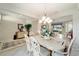 Elegant dining room featuring a chandelier, tile floors, and views into the living room at 9651 Se 137Th Street Rd, Summerfield, FL 34491