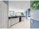 Open kitchen with white cabinets and a view into the living room at 9651 Se 137Th Street Rd, Summerfield, FL 34491