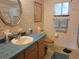 Clean bathroom with light blue tile, floral wallpaper, and a vanity at 11256 Sw 78Th Ave, Ocala, FL 34476