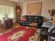 Living room features a red rug and black leather furniture at 11256 Sw 78Th Ave, Ocala, FL 34476