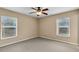 Bright bedroom with carpeted floor, ceiling fan, and two windows at 12854 Se 118Th Ter, Ocklawaha, FL 32179