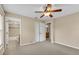 Neutral toned bedroom with ceiling fan, carpet and access to the bathroom offers a calming retreat at 12854 Se 118Th Ter, Ocklawaha, FL 32179