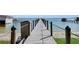 Long wooden dock extends over blue waters with rope railing in a lovely lakeside setting at 12854 Se 118Th Ter, Ocklawaha, FL 32179