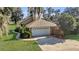 White garage door with a long driveway and landscaped yard at 12854 Se 118Th Ter, Ocklawaha, FL 32179