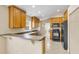 Kitchen with wood cabinets, black appliances, and tile flooring at 12854 Se 118Th Ter, Ocklawaha, FL 32179