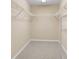 Spacious walk-in closet with built-in shelving and neutral carpet, perfect for organized storage at 12854 Se 118Th Ter, Ocklawaha, FL 32179