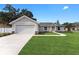 Newly constructed home with a landscaped lawn and attached garage at 1302 Ne 22Nd Ave, Ocala, FL 34470